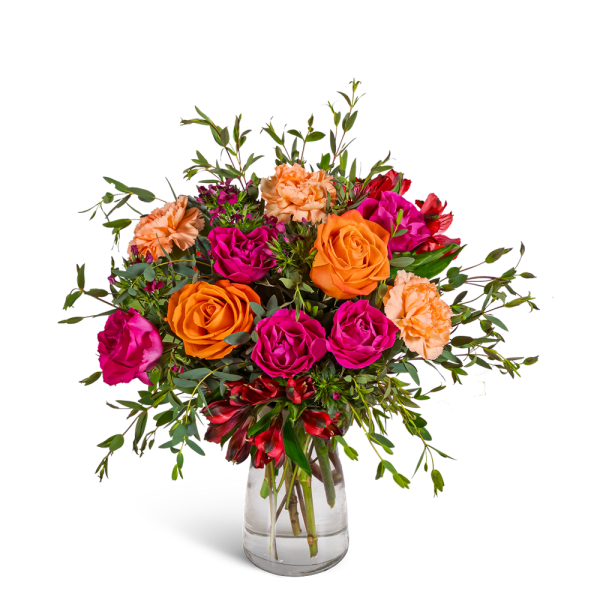 Bouquet of orange and magenta roses with peach carnations in a clear glass vase