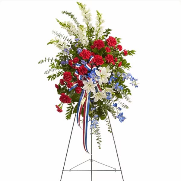 Standing floral spray with red, white, and blue flowers on an easel