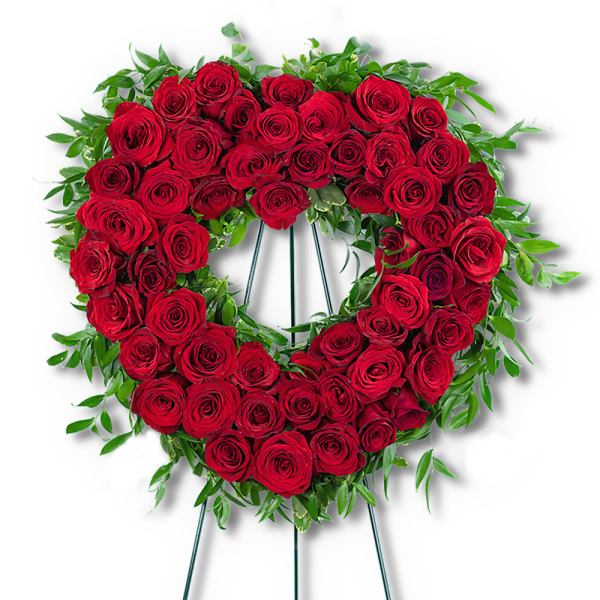 Heart-shaped wreath of red roses with green foliage on a stand