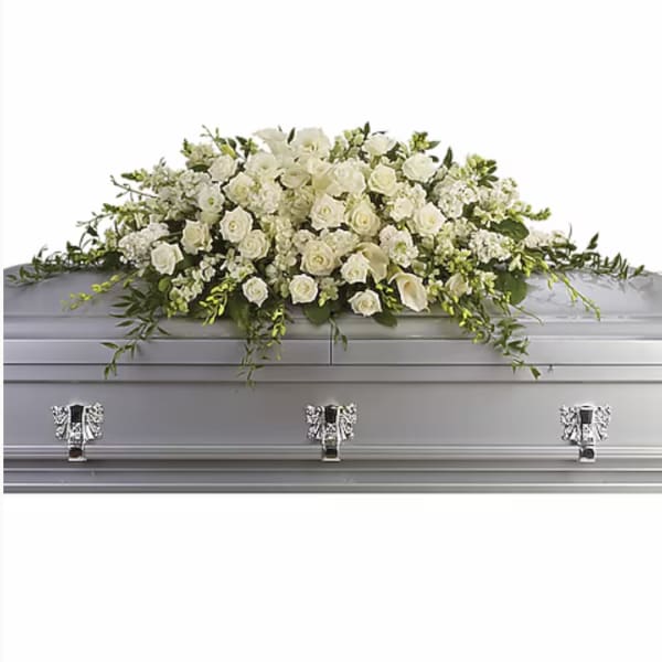 White floral casket spray with roses, calla lilies, and greenery