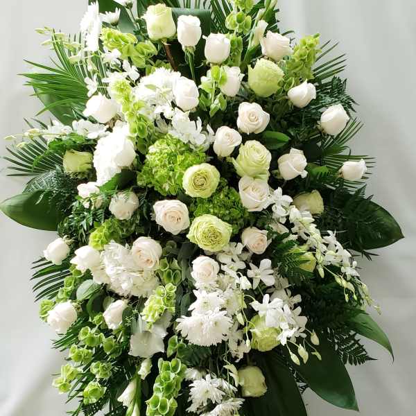 Large white and green floral standing spray on an easel