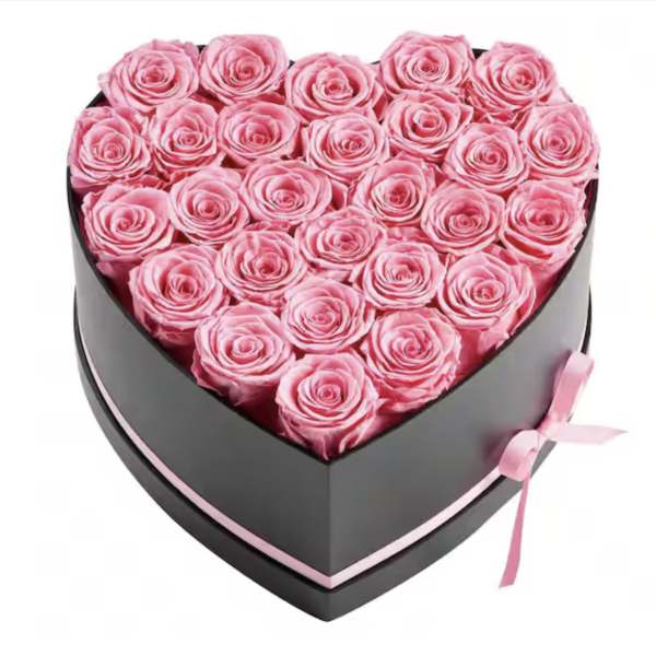 Heart-shaped box filled with pink roses and tied with a pink ribbon