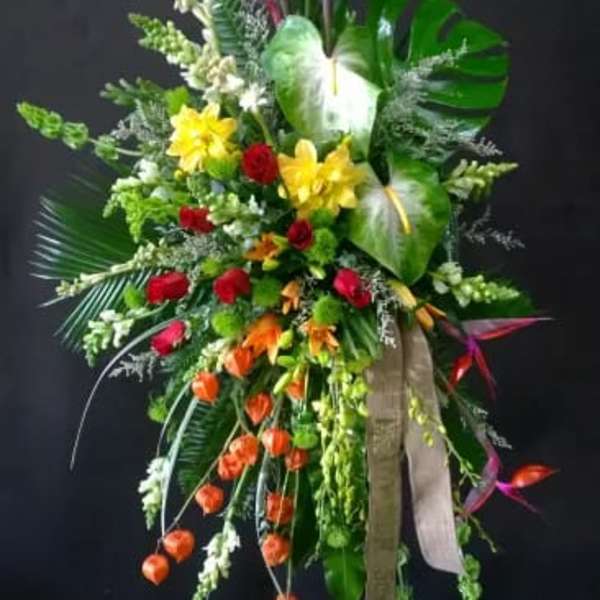 Tall tropical floral standing spray with red, yellow, and orange blooms