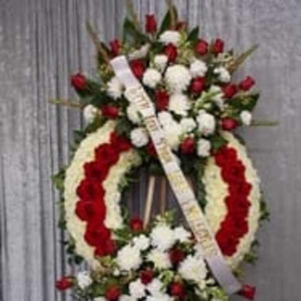 Standing funeral wreath with red and white flowers on an easel