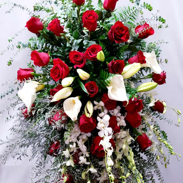 Large standing arrangement of red roses and white calla lilies