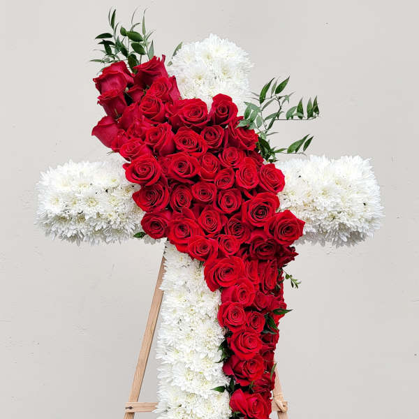 Red rose cross with white flowers on a wooden easel