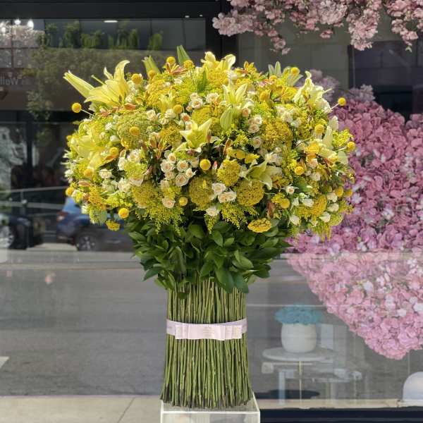 Large yellow floral arrangement with lilies and small roses