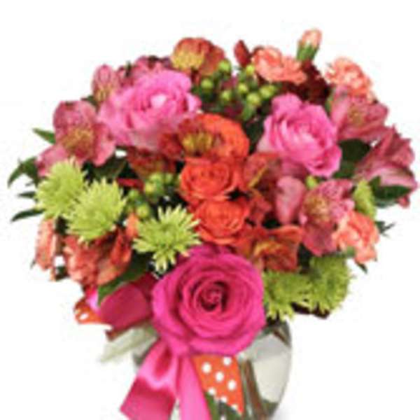 Pink and orange mixed bouquet in a glass vase with a ribbon