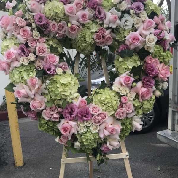 Heart-shaped floral wreath with pink and purple roses and green hydrangeas