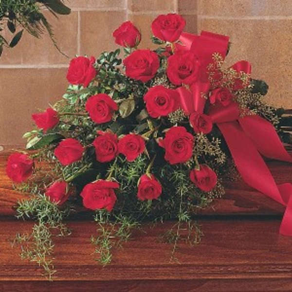 Bouquet of red roses with a red ribbon on a wooden surface