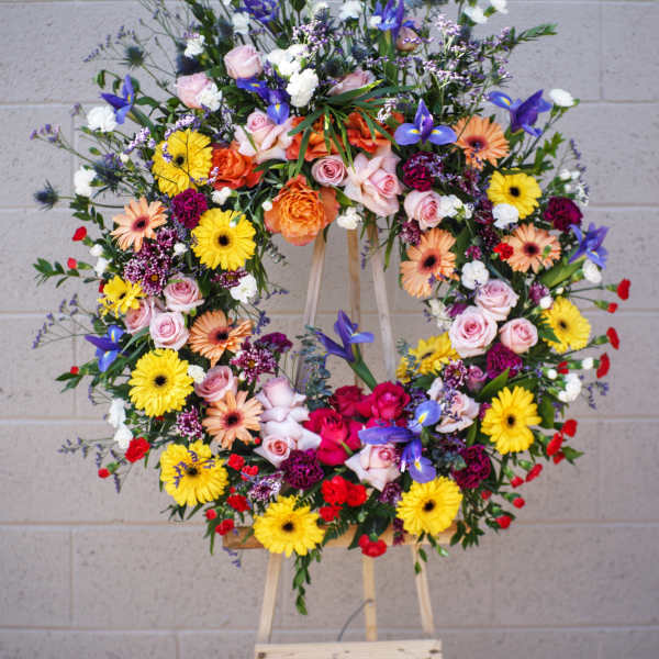 Large colorful floral wreath on a wooden easel