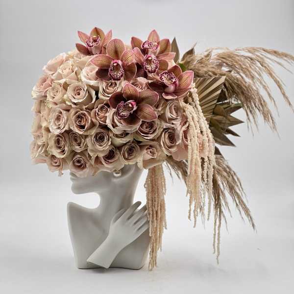Blush rose and orchid arrangement on a mannequin bust with dried grasses