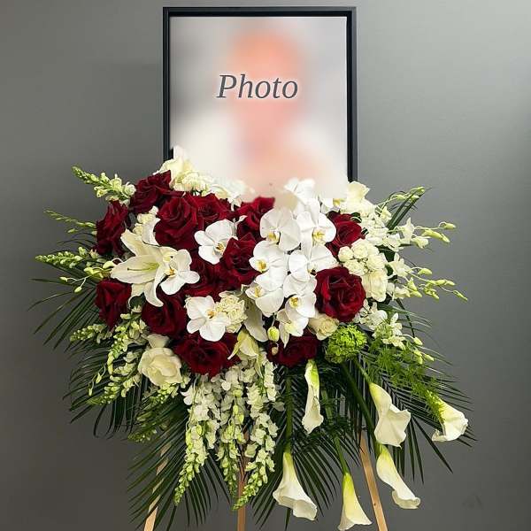 Standing floral spray with red roses, white orchids, and white calla lilies