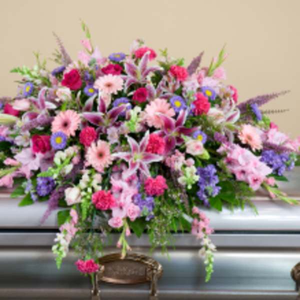 Large pink and purple funeral spray on a casket