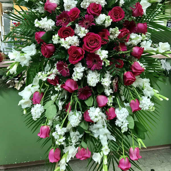 Large standing spray of pink roses, gerbera daisies, and white flowers