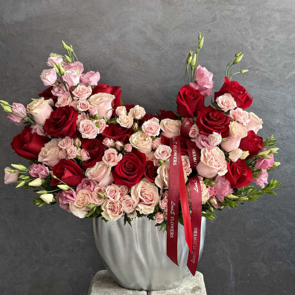 Large bouquet of red and blush roses in a silver vase