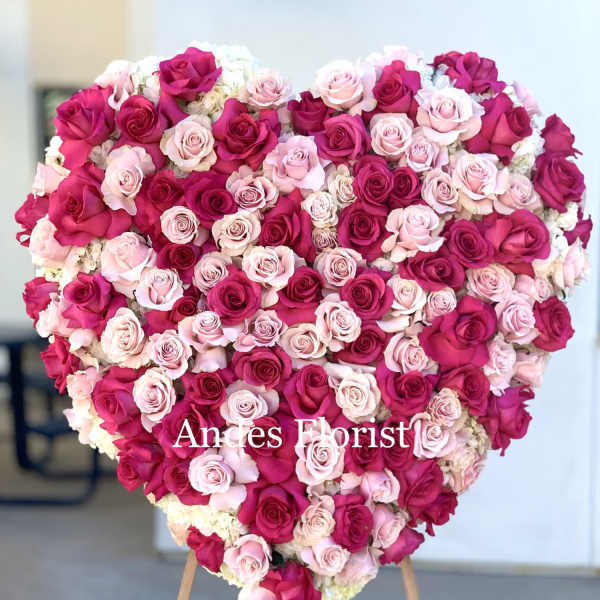 Heart-shaped arrangement of pink and magenta roses on an easel