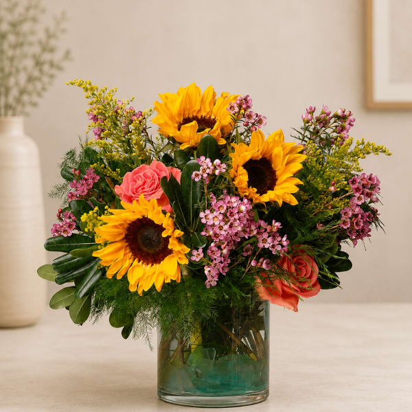 Sunflower and rose arrangement in a clear glass vase
