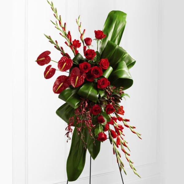 Tall red rose arrangement with anthuriums and tropical foliage