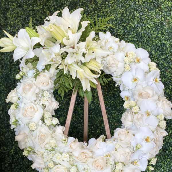 White floral wreath on a wooden easel