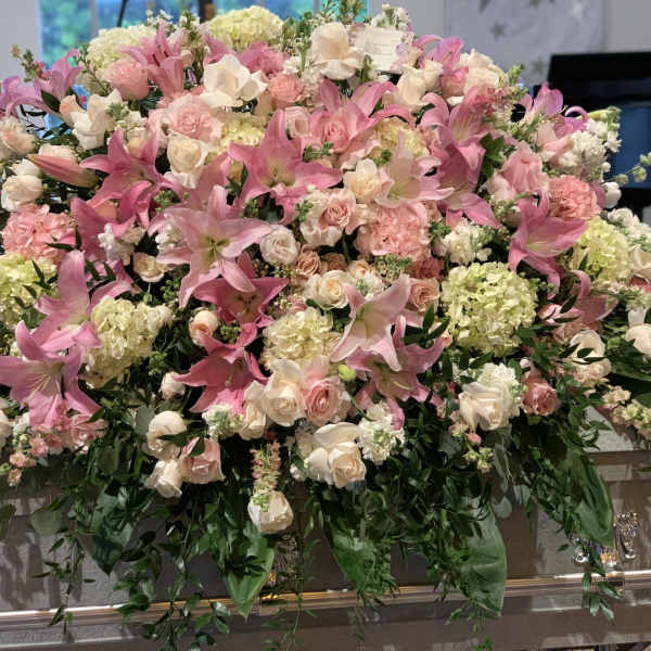 Large pink and white floral casket spray with lilies and roses