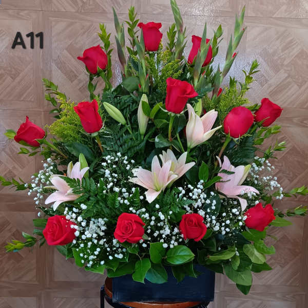Large arrangement of red roses and pale lilies with baby's breath