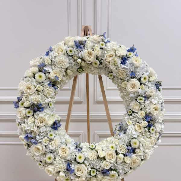 Large white floral wreath on a wooden easel