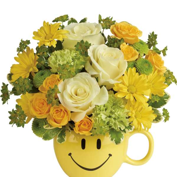 Yellow smiley-face mug filled with yellow and white flowers