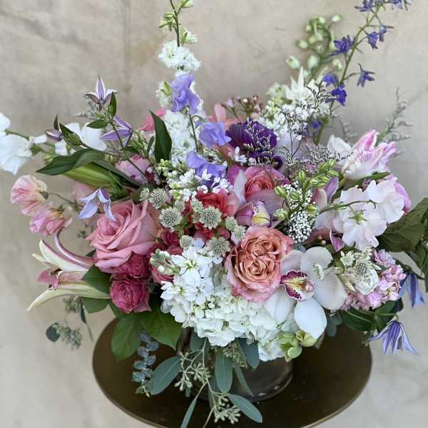 Mixed pink, white, and purple floral arrangement in a vase