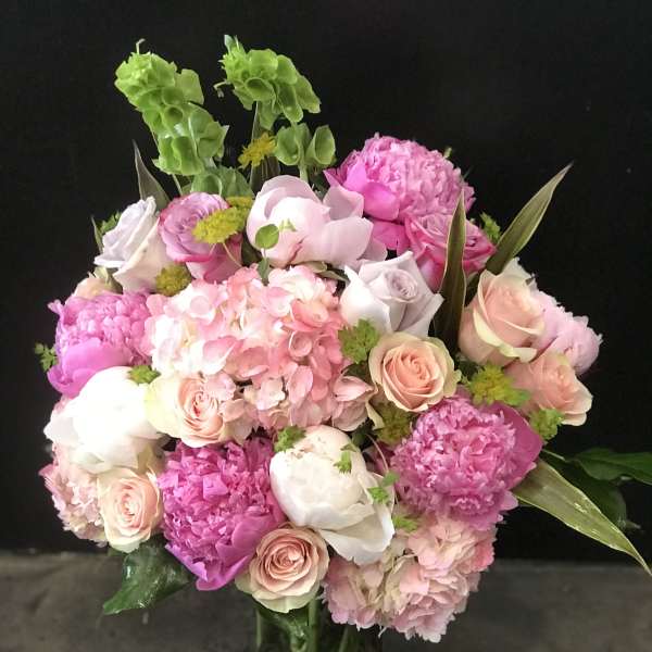 Pink and white bouquet of roses and hydrangeas in a glass vase