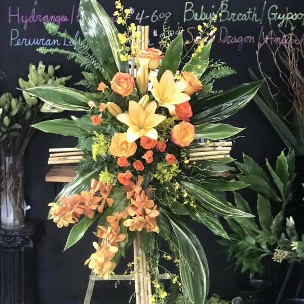 Tall orange and yellow floral standing spray on an easel