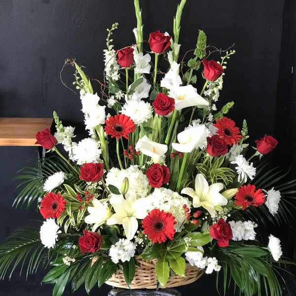 Large basket arrangement with red roses, white lilies, and red gerbera daisies