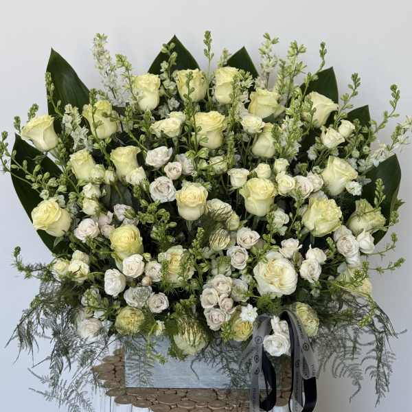 Large bouquet of cream roses and white spray roses with greenery