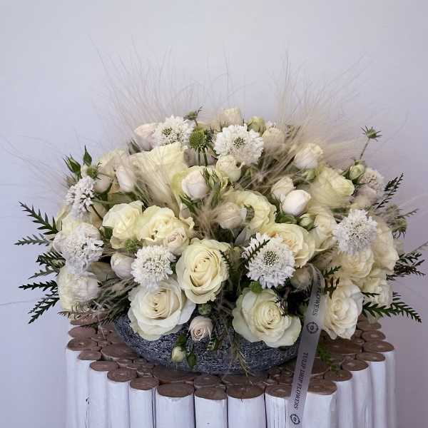 Cream rose bouquet with white accent flowers in a low container