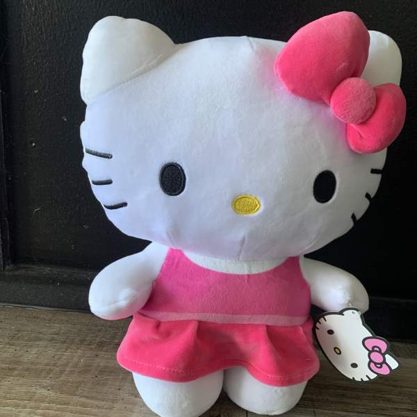 Hello Kitty plush toy in a pink dress with a bow