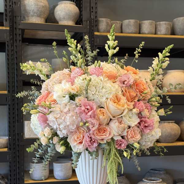 Large pastel flower arrangement in a white vase
