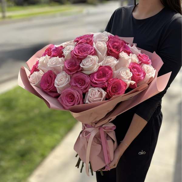 Large bouquet of pink and white roses wrapped in pink paper