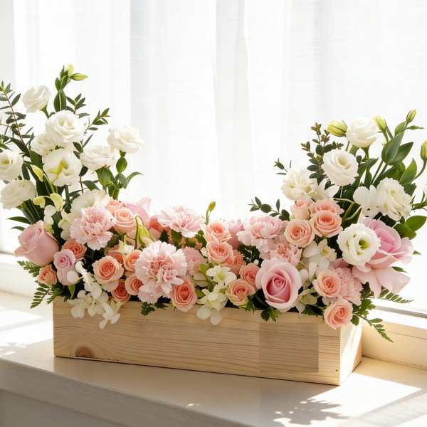 Pink and white floral arrangement in a wooden box