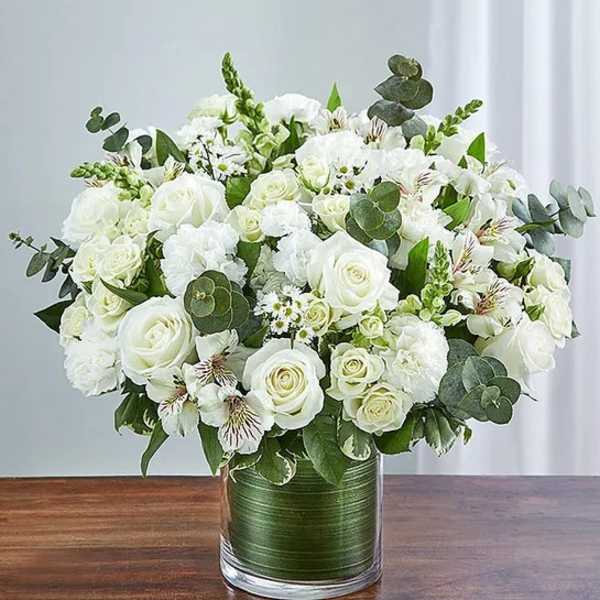 White roses and mixed white flowers in a glass vase