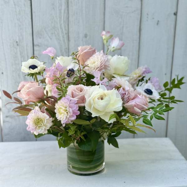Pastel bouquet of roses and mixed blooms in a clear glass vase