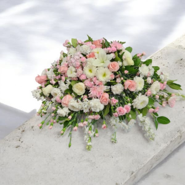 Pink and white floral spray on a stone surface