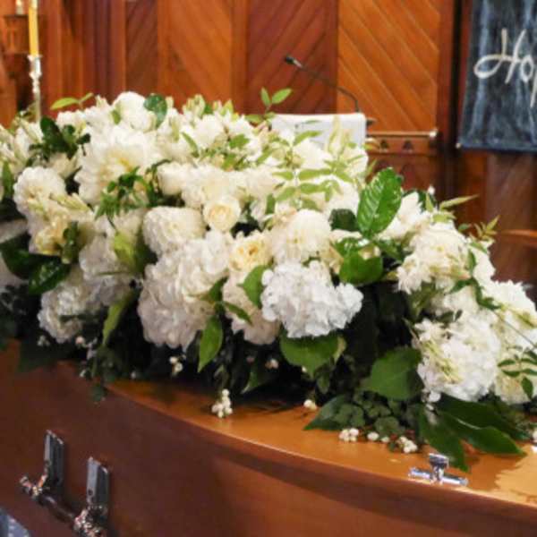 Large white floral spray on a casket