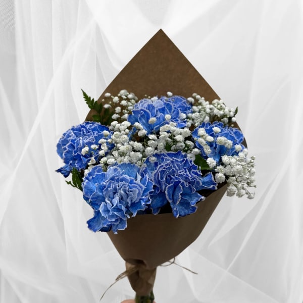 Blue carnations with white baby's breath in brown paper wrap