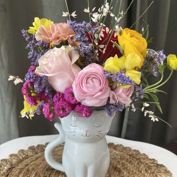 Colorful bouquet in a white cat-shaped mug vase