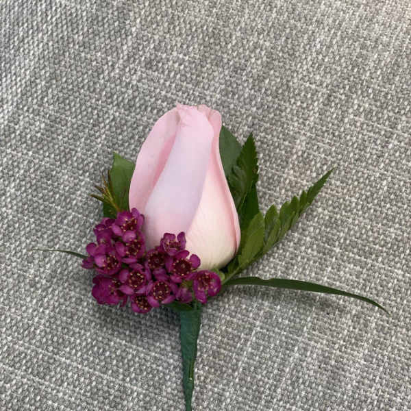 Pink rose boutonniere with small purple accent flowers
