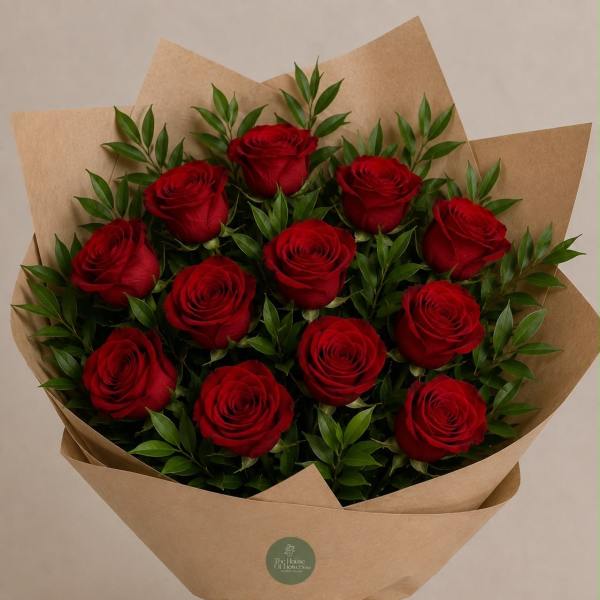 Bouquet of red roses wrapped in brown paper with a raffia bow