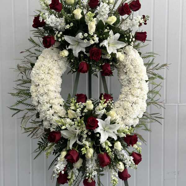Standing floral wreath with red and white roses and lilies