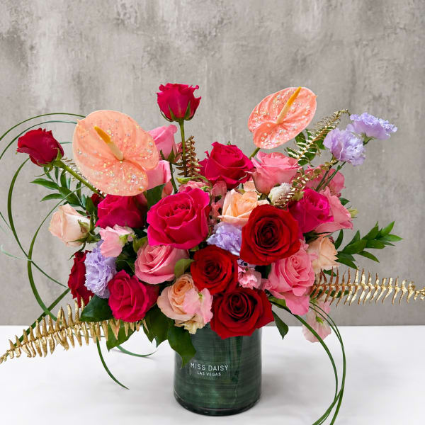 Mixed roses and anthuriums in a green vase