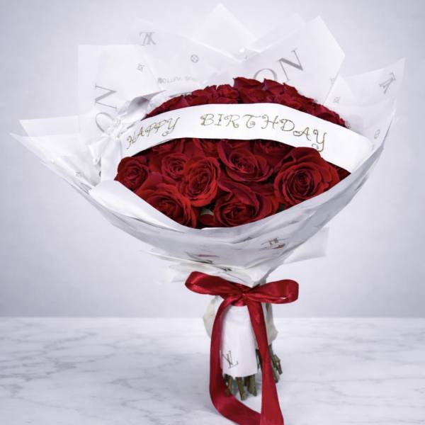Bouquet of red roses wrapped in white paper with a red ribbon