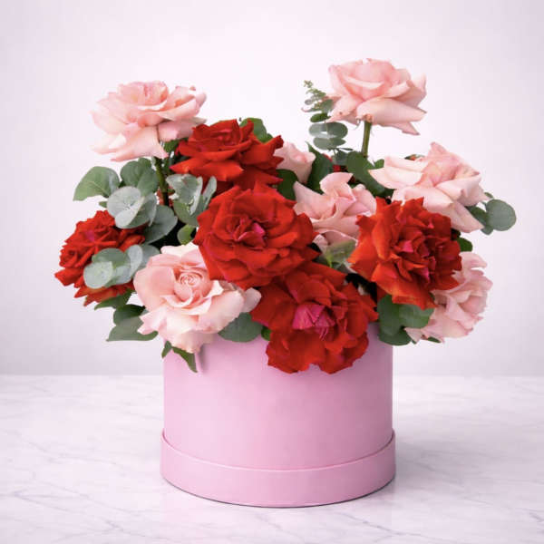 Pink and red roses arranged in a round pink box